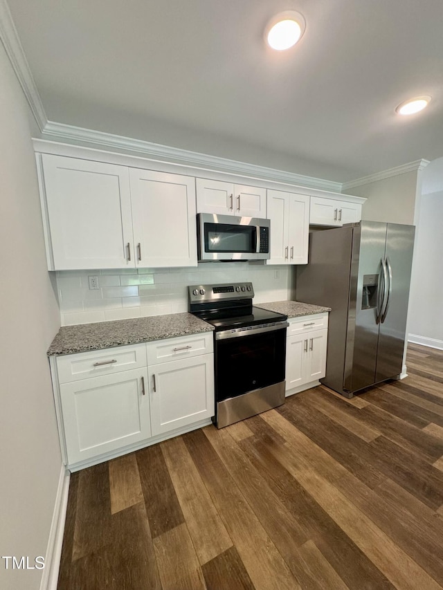 306 E Roseboro St, Roseboro, NC 28382 - kitchen featuring appliances with stainless steel finishes, crown molding, dark wood finished floors, white cabinetry, and light stone countertops