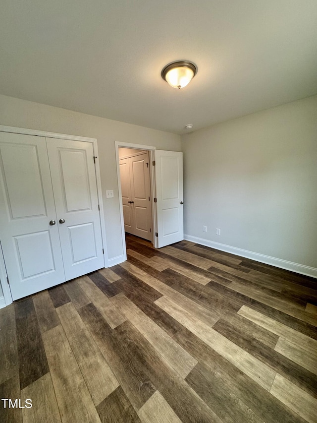 306 E Roseboro St, Roseboro, NC 28382 - unfurnished bedroom with dark wood-style floors, baseboards, and a closet