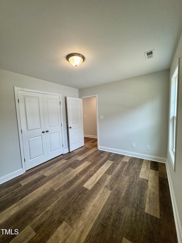 306 E Roseboro St, Roseboro, NC 28382 - unfurnished bedroom with baseboards, dark wood-type flooring, and a closet
