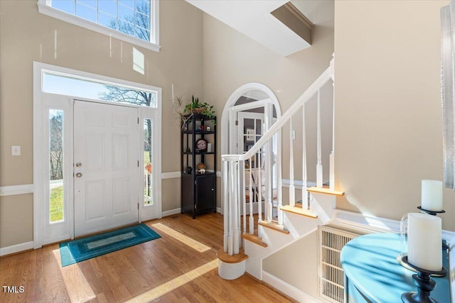 foyer entrance with stairway, a healthy amount of sunlight, and wood finished floors