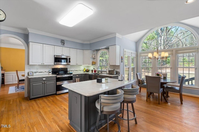 kitchen with open shelves, gray cabinetry, stainless steel appliances, light countertops, and white cabinets