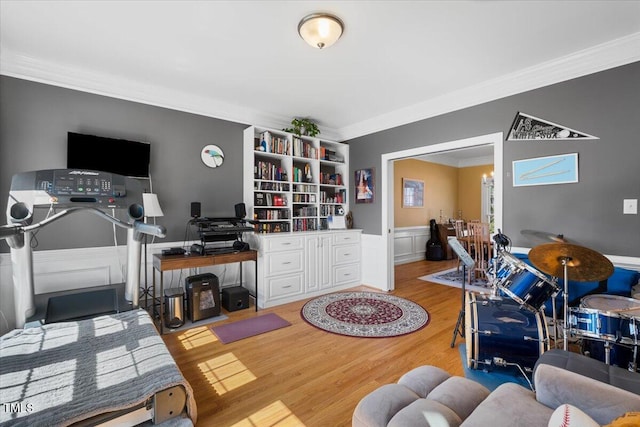 office area with wood finished floors, wainscoting, and ornamental molding