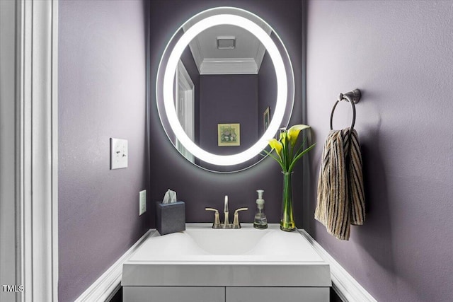 bathroom with vanity, crown molding, and a textured wall