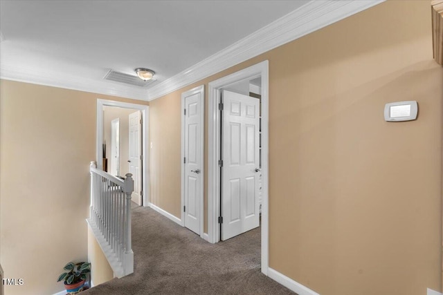 hallway with an upstairs landing, crown molding, baseboards, and carpet floors