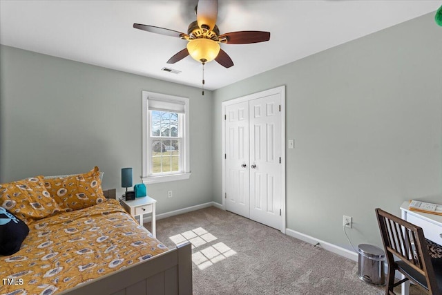 bedroom with baseboards, visible vents, carpet floors, ceiling fan, and a closet