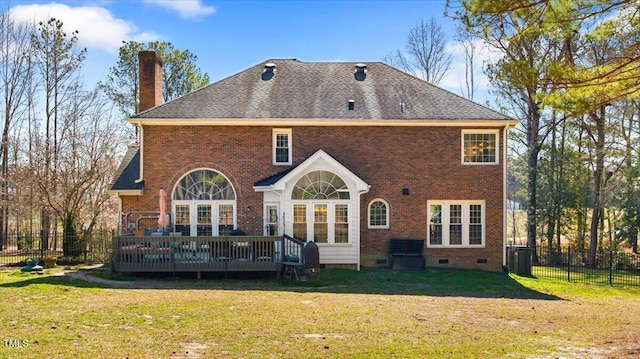 rear view of property with fence, a wooden deck, a yard, a chimney, and brick siding