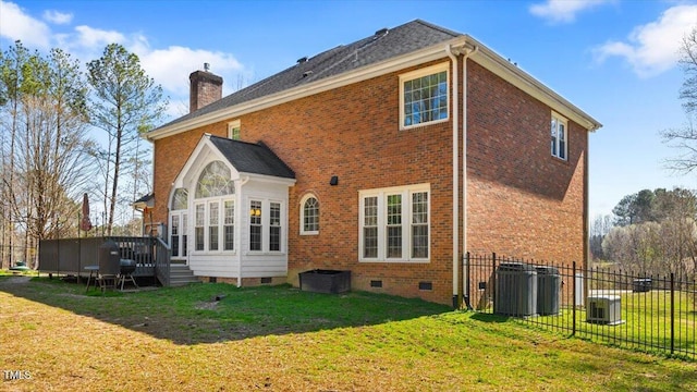 back of property with fence, a wooden deck, a lawn, a chimney, and crawl space