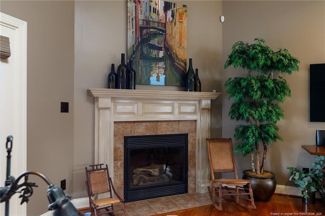 sitting room featuring wood finished floors, baseboards, and a tile fireplace