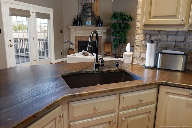 kitchen with a sink, tasteful backsplash, and a fireplace