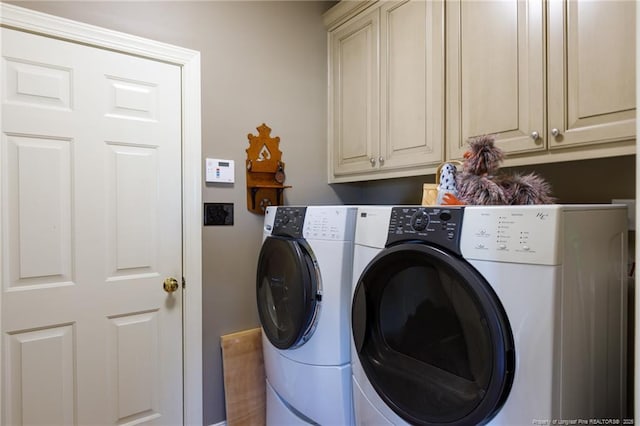 washroom featuring cabinet space and washing machine and clothes dryer