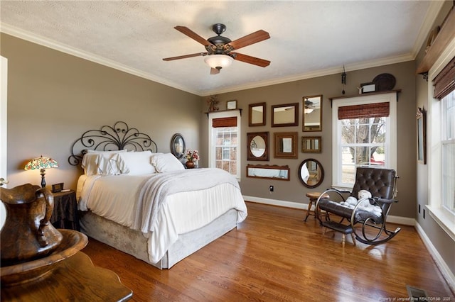 bedroom featuring baseboards, multiple windows, wood finished floors, and ornamental molding