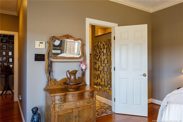 bedroom with dark wood-style floors, baseboards, and ornamental molding