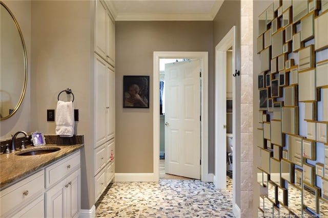 full bathroom with vanity, crown molding, and baseboards