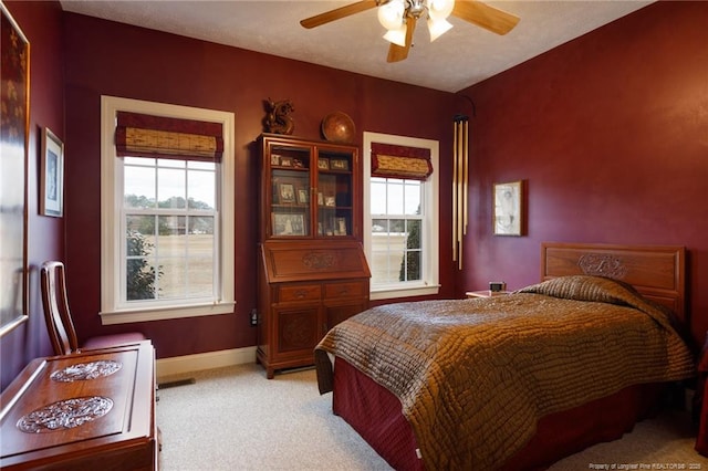 bedroom featuring light colored carpet, baseboards, and ceiling fan