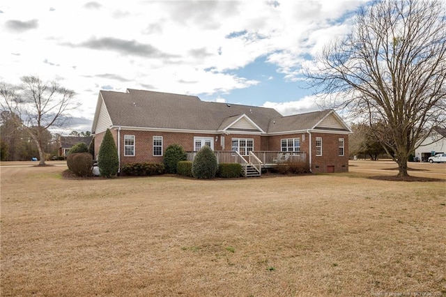 view of front of property featuring brick siding, a deck, and a front yard