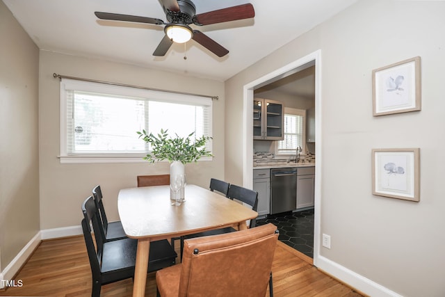 dining area featuring baseboards, light wood finished floors, and ceiling fan