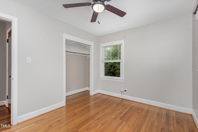 unfurnished bedroom with a closet, baseboards, and light wood-style flooring