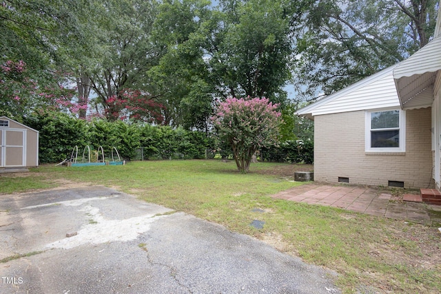 view of yard featuring a storage shed, an outbuilding, and a patio