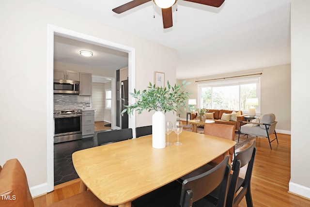 dining space featuring baseboards, light wood-type flooring, and a ceiling fan