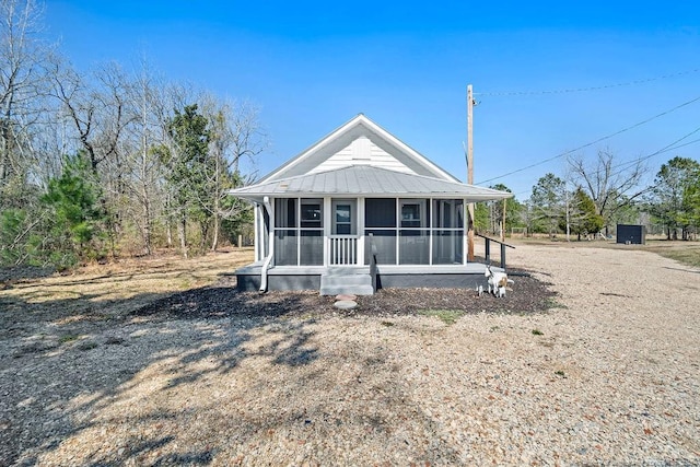 rear view of house featuring metal roof and a sunroom