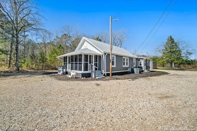 view of front of property with metal roof, central AC, and a sunroom