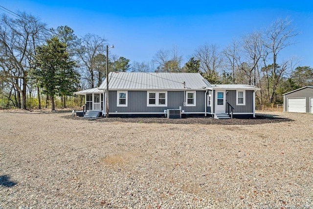 view of front facade featuring an outbuilding, entry steps, cooling unit, a sunroom, and a garage