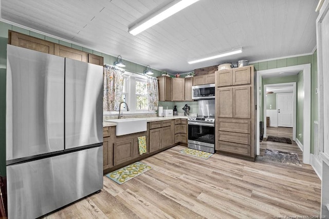 kitchen featuring a sink, light wood-style floors, appliances with stainless steel finishes, light countertops, and wood ceiling