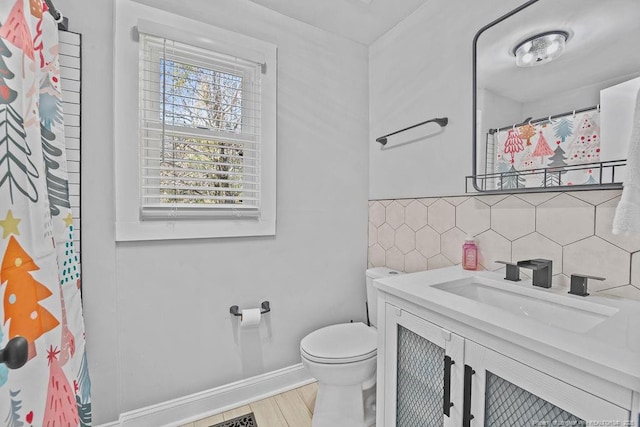 full bath featuring vanity, baseboards, curtained shower, tile walls, and toilet