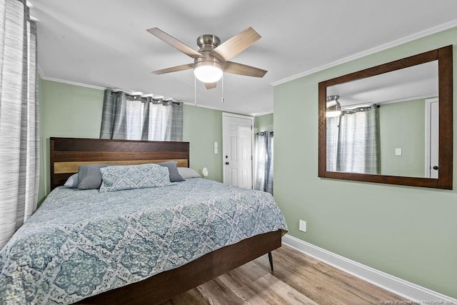 bedroom with wood finished floors, a ceiling fan, baseboards, and ornamental molding