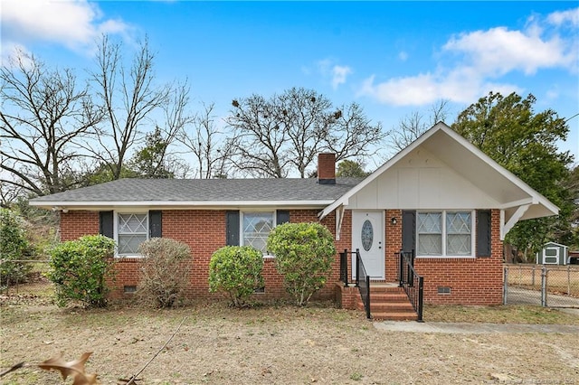 view of front facade with fence, brick siding, a chimney, crawl space, and board and batten siding