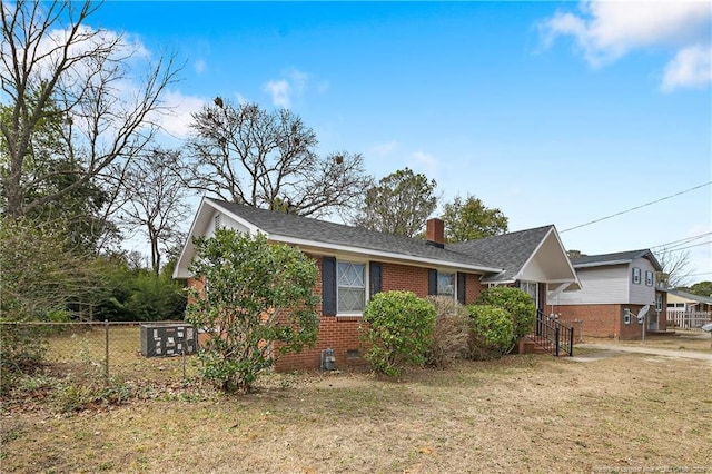 view of front of house with fence, a front yard, crawl space, brick siding, and a chimney