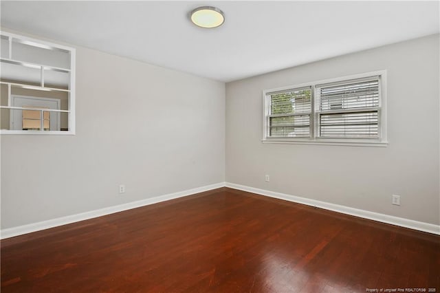 unfurnished room featuring baseboards and wood finished floors