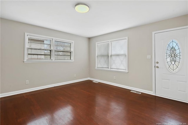 entrance foyer featuring visible vents, baseboards, and wood finished floors