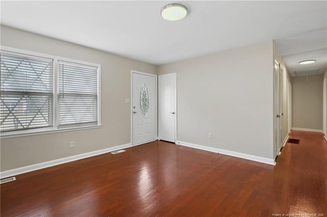 foyer entrance featuring visible vents, baseboards, and wood finished floors