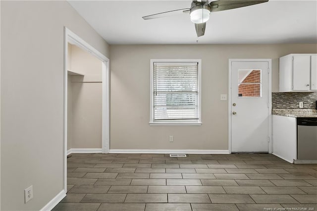 kitchen with baseboards, ceiling fan, dishwasher, decorative backsplash, and white cabinets