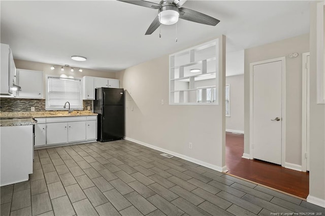 kitchen with backsplash, light countertops, freestanding refrigerator, white cabinets, and a ceiling fan