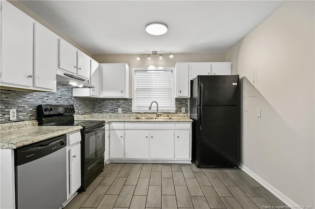 kitchen with under cabinet range hood, decorative backsplash, black appliances, and a sink