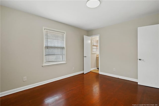 empty room featuring baseboards and wood finished floors