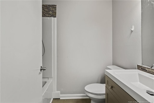 bathroom with vanity, toilet, washtub / shower combination, and baseboards