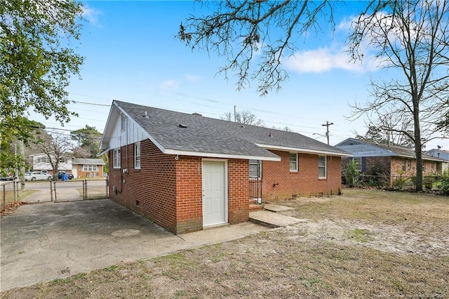 back of house with crawl space, fence, brick siding, and a gate