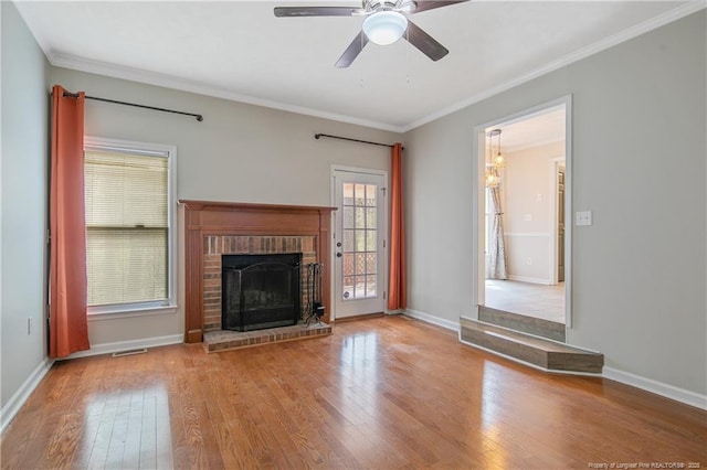 unfurnished living room featuring ornamental molding, a fireplace, a ceiling fan, and wood-type flooring