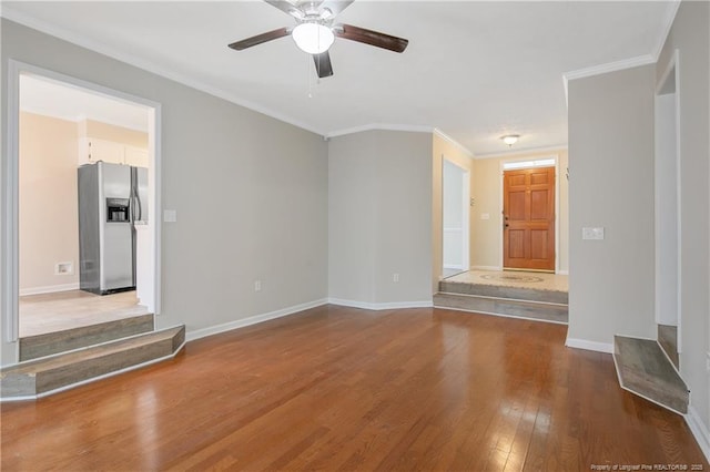 unfurnished living room with hardwood / wood-style floors, a ceiling fan, baseboards, and ornamental molding