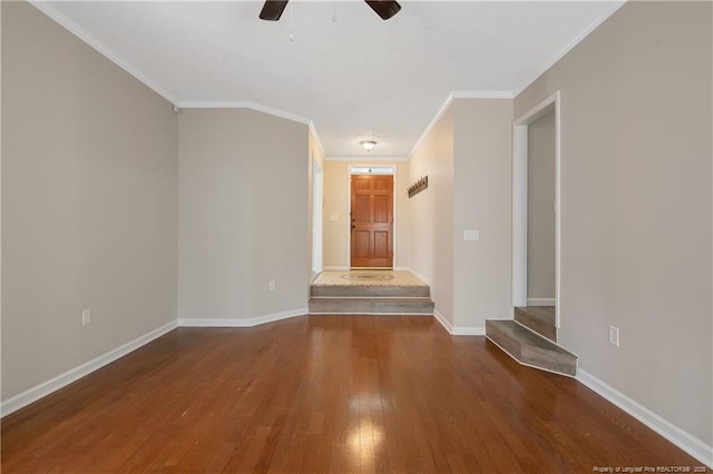 spare room featuring ceiling fan, baseboards, wood finished floors, and crown molding