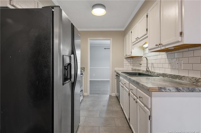 kitchen with a sink, ornamental molding, stainless steel appliances, white cabinetry, and backsplash