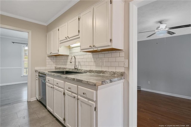 kitchen with ornamental molding, a sink, backsplash, white cabinetry, and dishwasher