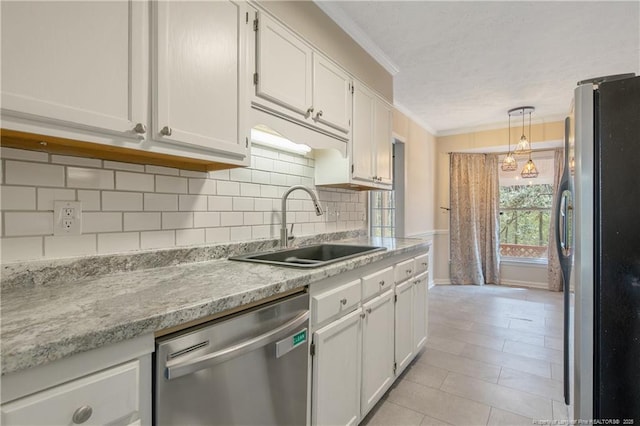 kitchen featuring ornamental molding, a sink, white cabinetry, stainless steel appliances, and light countertops