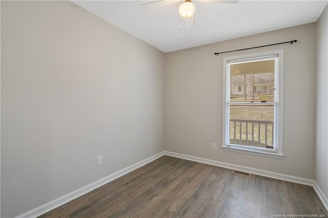 empty room with baseboards, wood finished floors, visible vents, and ceiling fan