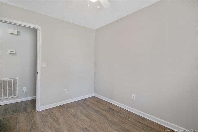 spare room with visible vents, baseboards, and wood finished floors