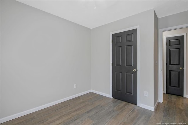 unfurnished bedroom with baseboards and wood finished floors