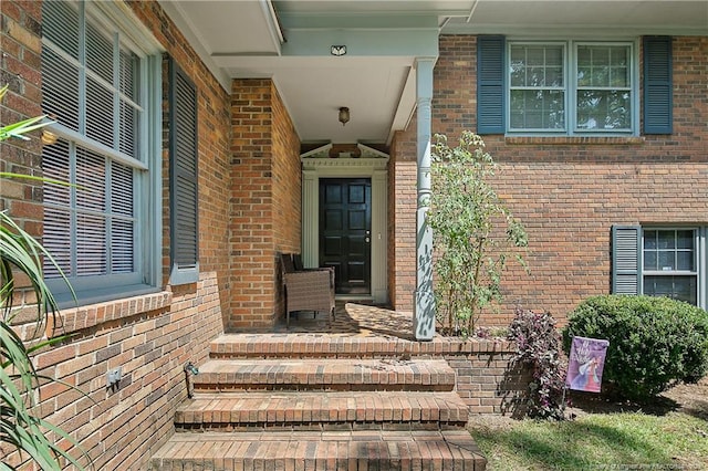 property entrance with brick siding and covered porch